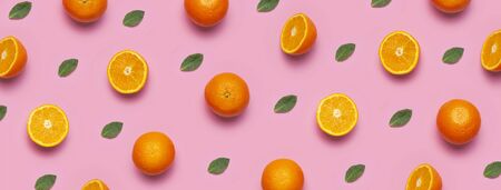 Fruit pattern, creative summer concept. Fresh juicy whole and sliced orange, mint leaves on pink background. Flat lay Top view. Minimalistic background with citrus fruits, vitamin C. Pop art design.の写真素材