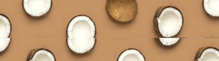 Creative layout with coconuts pattern. Whole and half coconut on brown background. Minimal flat lay style, top view copy space. Food concept. Tropical exotic fruit, summer golden background. Banner.の写真素材