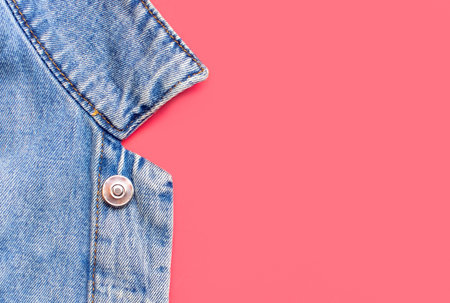 Close-up Blue denim jacket on pink background top view flat lay copy space. Denim, fashionable jacket, womens or mens trend clothing, fashion background. Denim texture.の写真素材