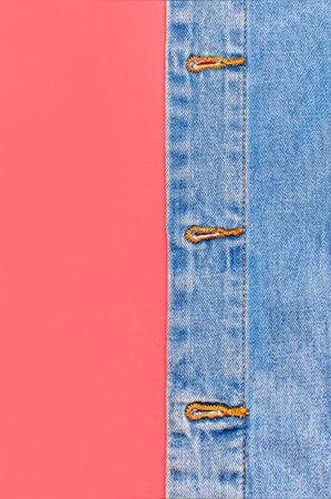 Close-up Blue denim jacket on pink background top view flat lay copy space. Denim, fashionable...