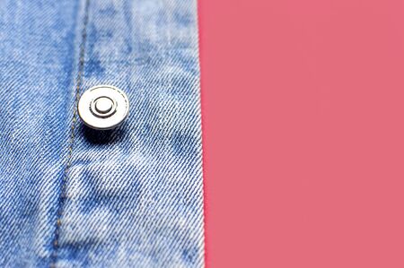 Close-up Blue denim jacket on pink background top view flat lay copy space. Denim, fashionable jacket, women's or men's trend clothing, fashion background. Denim texture.の写真素材