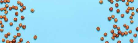 Creative food layout. Hazelnuts on blue background top view copy space. Concept of food, healthy nutrition, nut, healthy fats. Hazelnut Flat lay. Walnut pattern. Organic healthy vegan snack.の写真素材