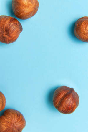 Creative food layout. Hazelnuts on blue background top view copy space. Concept of food, healthy nutrition, nut, healthy fats. Hazelnut Flat lay. Walnut pattern. Organic healthy vegan snack macro shot.の写真素材