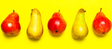 Juicy ripe fresh green and red pears on yellow background flat lay top view copy space. Creative...