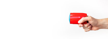 Red deodorant in male hand isolated on white background. Men's deodorant, personal hygiene products, men's cosmetics. Red clean plastic deodorant packaging, mockup for advertising, place for text.の写真素材