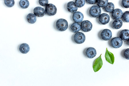 blueberry background. Fresh juicy blueberries with green leaves on white background. Flat lay top view copy space. Healthy berry, organic food, antioxidant, vitamin, blue food. blueberry frame.の写真素材