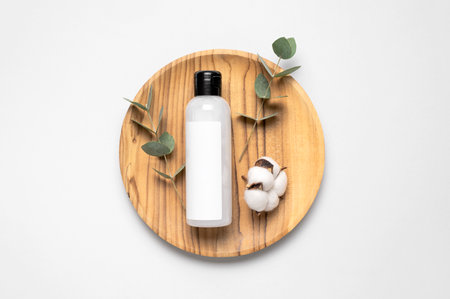 natural organic eco cosmetics. Beauty SPA branding mock-up. Cosmetic containers with cream and lotion, cotton flowers, eucalyptus leaves on gray background flat lay top view. Blank label for branding.の写真素材