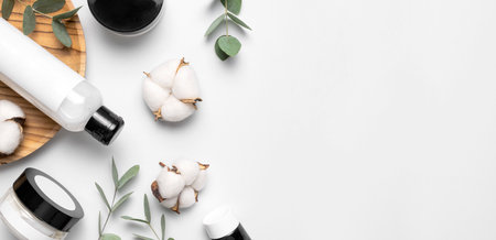 natural organic eco cosmetics. Beauty SPA branding mock-up. Cosmetic containers with cream and lotion, cotton flowers, eucalyptus leaves on gray background flat lay top view. Blank label for branding.の写真素材