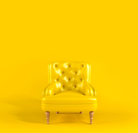 Yellow leather armchair with quilted back and wooden legs on yellow background front view. Creative minimalistic interior, stylish fashionable leather armchair, classic sofa, single piece of furniture.の写真素材