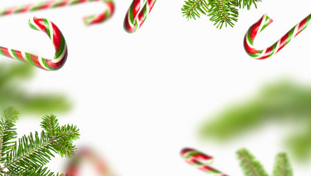 Frame made of traditional Christmas candy cane, green spruce branches on white background. Creative new year concept. Festive decor, sweetness, caramel candy. Christmas holiday symbol, decoration.の写真素材