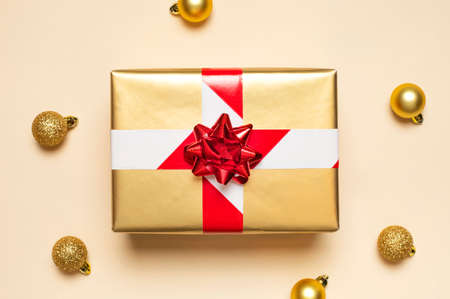New Year and Christmas 2021 banned. Golden gift with prohibiting red and white tape, Christmas balls on beige background flat lay top view. Holidays in quarantine. Coronavirus 2019-nCoV. Stay at home.の写真素材