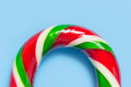 Traditional Christmas candy cane, lollipop on blue background flat lay top view macro photo. New...