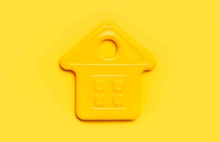 House symbol on yellow background flat lay top view copy space. Model of plastic yellow house. Concept of buying home, apartment. Renting a house, real estate. Mortgage, credit, real estate insurance.の写真素材