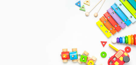 Children's toys made of natural wood on white background. Multi-colored pyramid, train, constructor, xylophone in rainbow colors. Eco friendly toy, plastic free. Toy for babies and toddlers Flat lay.の写真素材