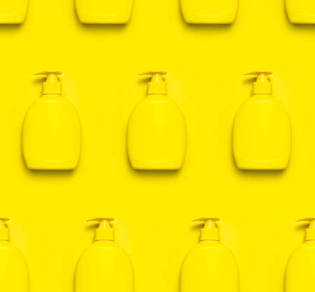 Yellow plastic cosmetic bottle container with dispenser on yellow background Seamless pattern Clean container without label for soap gel cream lotion shampoo bath foam. Beauty spa branding mockups.の写真素材