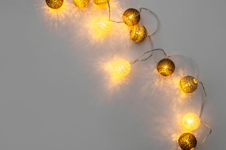 Festive included garland on gray background flat lay top view. Cotton Balls Garland. Round bulbs LED...