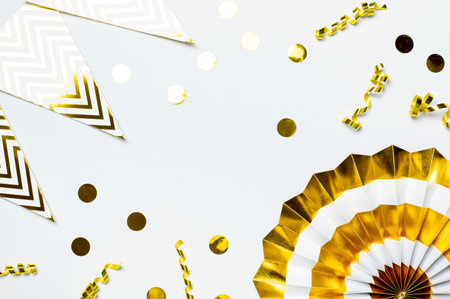 Festive white and gold paper fans, gold confetti for party, birthday, holiday, wedding on light background top view. origami. decorative objects. Colorful abstract background. Festive trendy backdrop.の写真素材