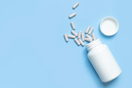 Pills, tablets, vitamins, food supplement in capsules, white plastic bottle on blue background....