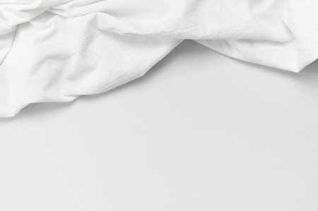 natural line background. White crumpled natural cotton fabric on light gray background top view flat...