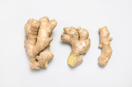 Fresh ginger root on light gray background top view flat lay. Spice for cooking, herbal tea with ginger to boost immunity. Natural organic ginger for health, medicine, protection against colds.の写真素材