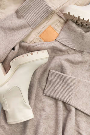 Female beige sweater turtleneck jumper, beige jeans, leather boots on light gray background top view. Fashion, style. Clothing concept for branding advertising Mock up. spring autumn clothes.の写真素材