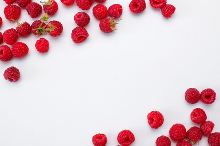 Ripe juicy fresh raspberries on white background flat lay top view. Raspberry pattern. Organic...
