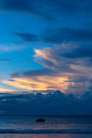 Beautiful bright sunset with colored clouds in the sky over the sea, ocean. Silhouette boat in the sea, lush clouds. Summer tropical natural background. travel concept. Thailand, Phuket island.の写真素材