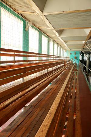Rows of empty wooden benches in sporting hall.の写真素材