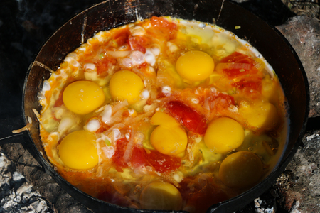 Scrambled egg fried on coals in pan on open fire, cook over an open fireの写真素材