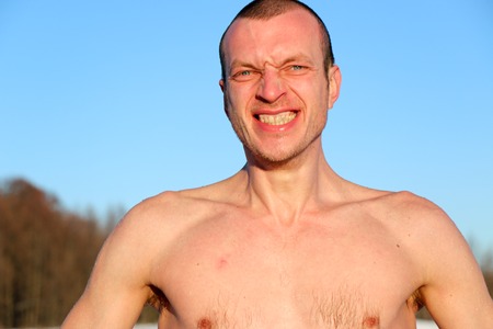 Young Good Looking And Attractive Man With Muscular Body, Taking after taking an ice bath. handsome attractive men showering next to swimming pool. water drops are falling on his torso. Sunny winter day in Ukraine, Shostkaの写真素材