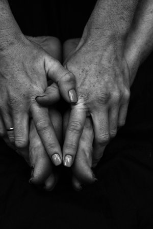 Female legs, hands. beautiful feet and palms on a black background, close-up. Black and white...