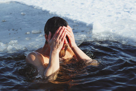 young, slim, handsome, sporty man with a red beard and long hair, naked, in black shorts, diving...