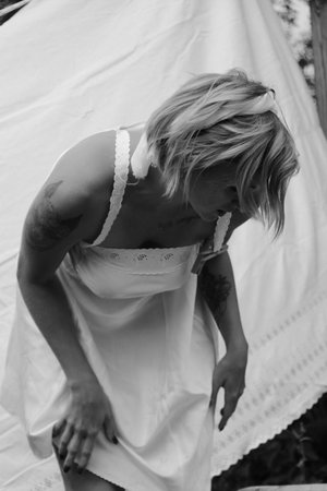 Dried laundry. Young beautiful sexy woman washes clothes and hangs underwear outdoors on a sunny day with a garden. black and white photo.の写真素材