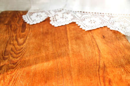 mocap old wooden board on white linen tablecloth and lace towel sunny natural light, shade. kitchen table. Nice retro, rustic background, free space.の写真素材
