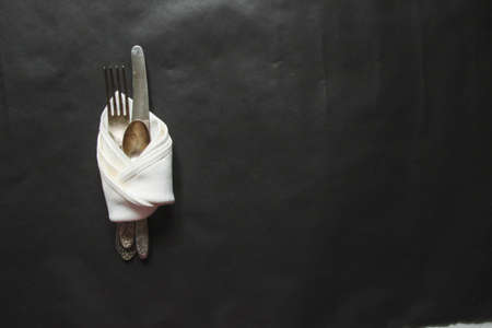 vintage silverware white napkin on black background of natural sunlight, shadow. view of the kitchen table, table setting. Plant branch with moldings Beautiful retro, rustic background, free space.の写真素材