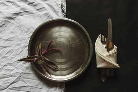 vintage silverware white napkin on black background of natural sunlight, shadow. view of the kitchen table, table setting. Plant branch with moldings Beautiful retro, rustic background, free space.の写真素材