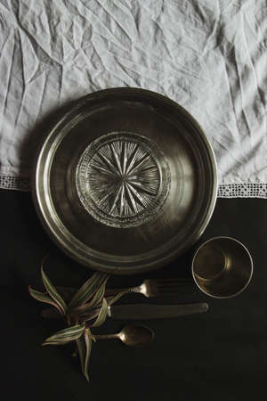 vintage silverware white napkin on black background of natural sunlight, shadow. view of the kitchen table, table setting. Plant branch with moldings Beautiful retro, rustic background, free space.の写真素材