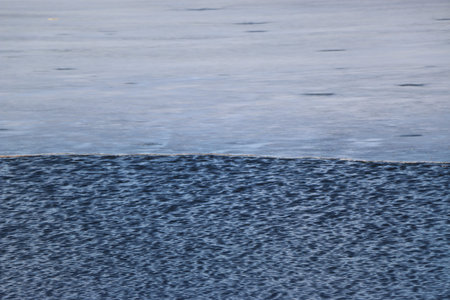 ripple texture of water surface on the background of a lake in spring with ice remnants on a sunny...