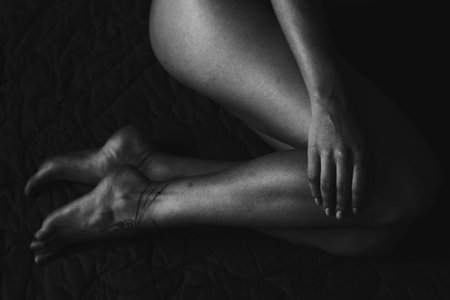 Close-up of female legs and hands with henna tattoo on the feet. Black and white photo. Gently feminine graceful decoration, respect for a woman, love and take care of yourself.の写真素材