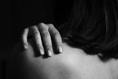 Beautiful black and white close-up photo of a woman's back and hand. Beauty, tranquility, tenderness, love and self-care. Body parts.の写真素材