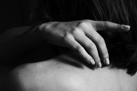 Beautiful black and white close-up photo of a woman's back and hand. Beauty, tranquility, tenderness, love and self-care. Body parts.の写真素材