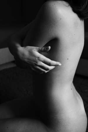 Beautiful black and white close-up photo of a woman's back and hand. Beauty, tranquility, tenderness, love and self-care. Body parts.の写真素材