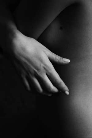 Beautiful black and white close-up photo of a woman's back and hand. Beauty, tranquility, tenderness, love and self-care. Body parts.の写真素材