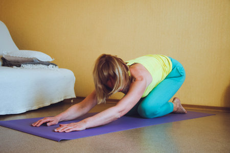 adult beautiful European Woman practicing home yoga. A series of yoga poses. pose of the child of...