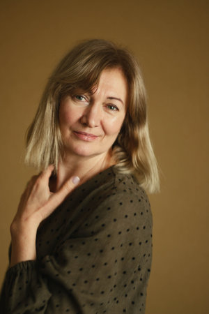 Casual portrait of a happy pensive mature woman with natural white hair and minimal makeup. In a...