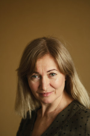 Casual portrait of a happy pensive mature woman with natural white hair and minimal makeup. In a...