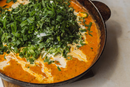 Shahi paneer sauce in a metal pan: a traditional vegetarian Indian dish of paneer cheese in tomato...