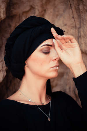 Portrait of a young beautiful woman with makeup and face art in tribal or Middle Eastern style.の写真素材