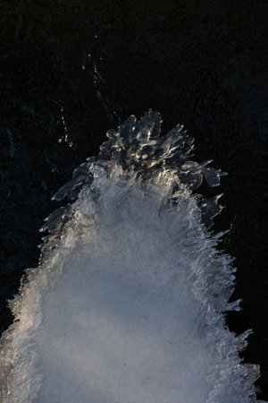 frosty ice over water. Winter Cold River, due to which ice, icicles, patterns formed. Sunny day, glare, radiation. Beautiful natural background, natural texture.の写真素材