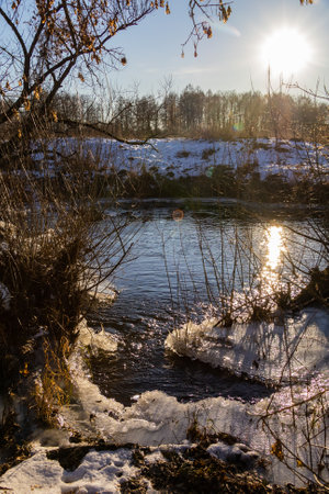 frosty ice over water. Winter Cold River, due to which ice, icicles, patterns formed. Sunny day, glare, radiation. Beautiful natural background, natural texture.の写真素材